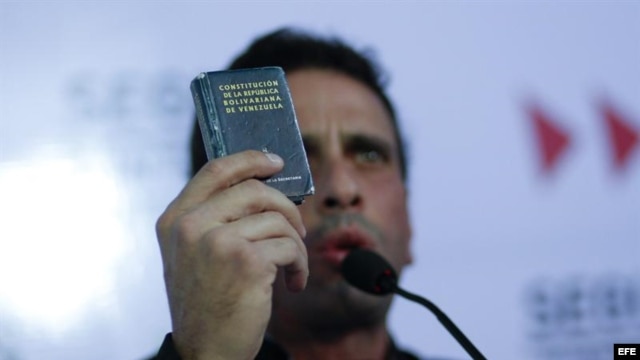 El líder de la oposición venezolana y actual gobernador del estado Miranda, Henrique Capriles, sostiene la Constitución del país durante una rueda de prensa, al conocer la decisión del Tribunal Supremo de Justicia respecto a Chávez.