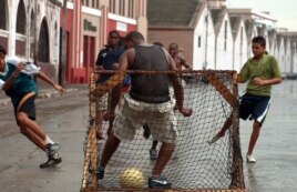 Jóvenes cubanos juegan fútbol soccer.