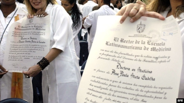 Varios jóvenes médicos muestran sus diplomas de recién graduados.