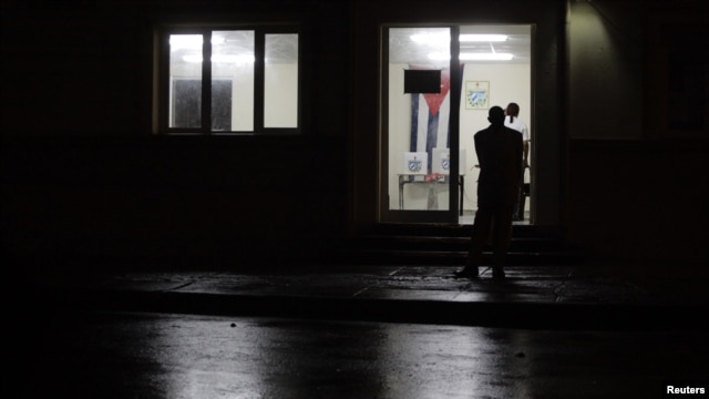 Un hombre espera que abran un colegio electoral en La Habana.
