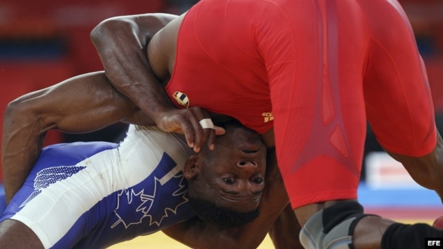 Archivo - El luchador cubano Livan Lopez Azcuy (rojo) se enfrenta al canadiense Haislan Veranes Garcia (azul) en Londres. 