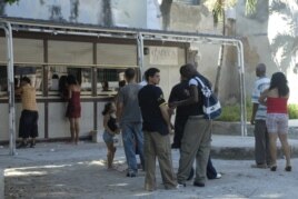 Varias personas hacen cola frente a una caja de cambio (CADECA).