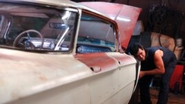 Un hombre repara un viejo Oldsmobile de la década del 50 en un taller particular en La Habana (Cuba).