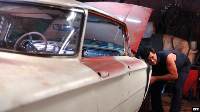 Un hombre repara un viejo Oldsmobile de la década del 50 en un taller particular en La Habana (Cuba).