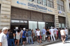 Varias personas hacen fila para ingresar a un telepunto y contratar el servicio de correo para sus teléfonos móviles en La Habana (Cuba).