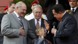 Hugo Chávez (d), saluda a Nikolai (c), hijo del presidente de Bielorusia, Alexander Lukashenko (c).