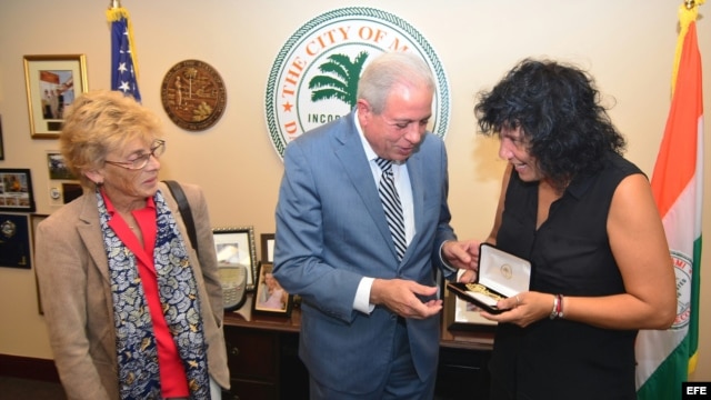 El alcalde de Miami, Tomás Regalado (c), entrega la llave dorada de la ciudad a la cantautora española Rosana (d) acompañado de la cónsul general de España en Miami, María Cristina Barrios Almazor (i). 