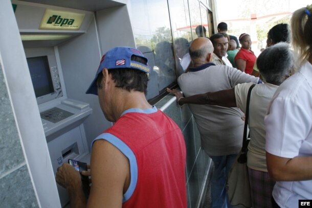Un hombre extrae dinero de un cajero automático en un banco de La Habana.