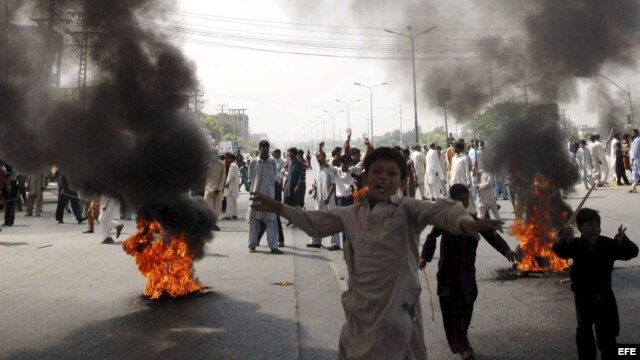 KHI06 LARKANA (PAKISTÁN) 21/09/2012.- Paquistaníes incendian neumáticos durante una manifestación contra la polémica película sobre Mahoma, en Pakistán, hoy, viernes 21 de septiembre de 2012. Las embajadas de Europa y EEUU han extremado la seguridad por t