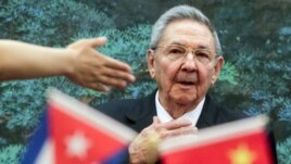 Raúl Castro durante un viaje a China, mientras ondea banderitas de Cuba y el país asiático.