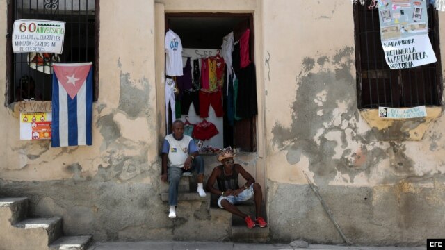 Dos hombres conversan en la entrada de una casa en la ciudad de Santiago de Cuba.