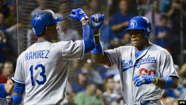 Hanley Ramirez (i) de los Dodgers de Los Angeles felicita a Yasiel Puig (d) tras batear un jonrón ante los Cachorros de Chicago durante un partido de la MLB.