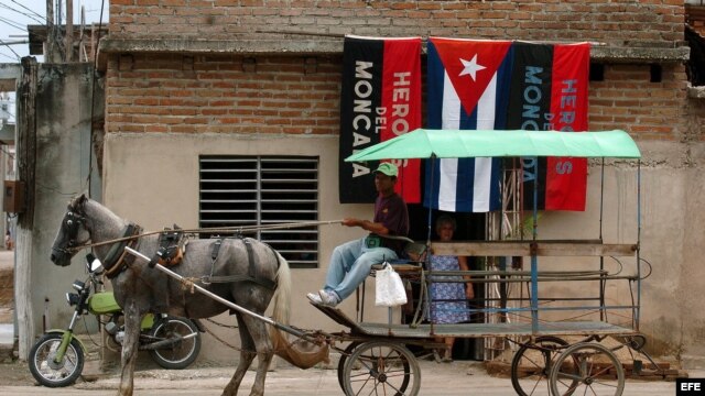  Un hombre conduce una carreta tirada por un caballo, en una calle de la provincia de Camaguey, Cuba. 