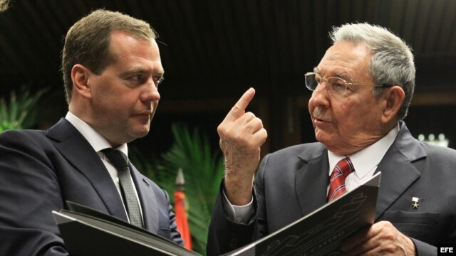 El primer ministro de Rusia Dimitri Medvedev (iz) y Raúl Castro observando un album de fotos.