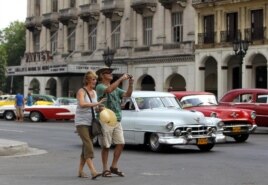Una pareja de turistas camina por una calle de La Habana.