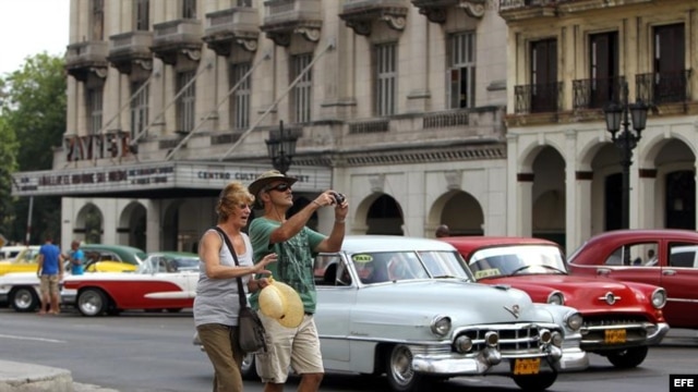 Una pareja de turistas camina por una calle de La Habana.