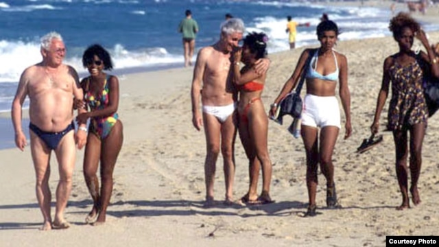 Adolescentes con extranjeros de edad muy avanzada en una playa cubana.