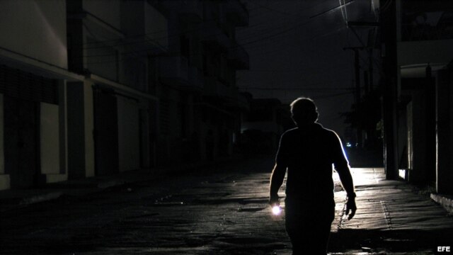 Un hombre camina con una linterna por el barrio de El Cerro, en La Habana, durante un apagón. EFE/Alejandro Ernesto