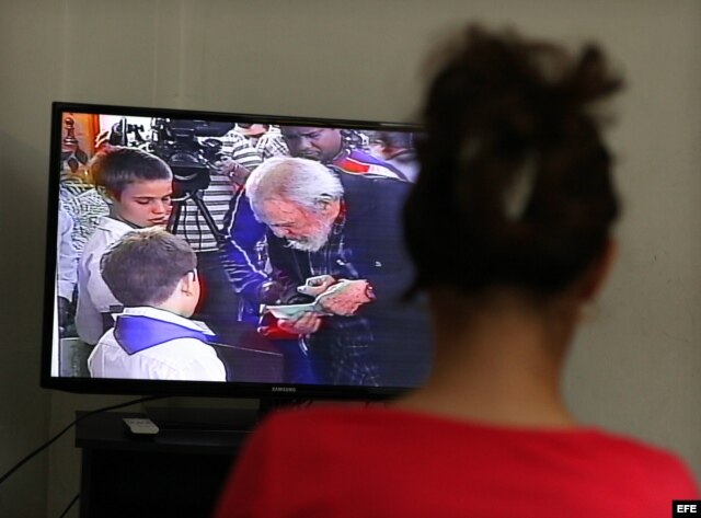 Una mujer observa el Noticiero Nacional de la Televisión cubana que muestra imágenes de Fidel Castro ejerciendo su derecho al voto.