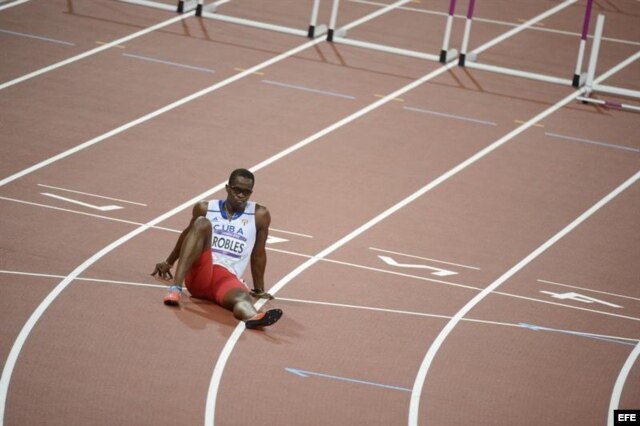 El cubano Dayron Robles se sienta en la pista en frustración por no terminar la prueba de los 110 metros vallas masculino.