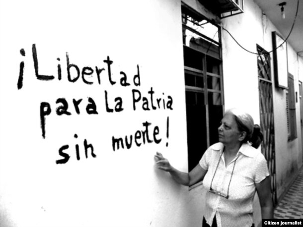La disidente Martha Beatriz Roque mostrando una pintada en su casa