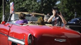 Un turista toma fotos desde un carro en La Habana.