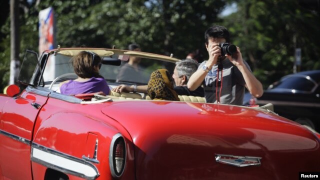 Un turista toma fotos desde un carro en La Habana.