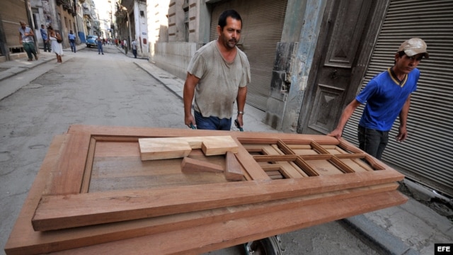 Un carpintero carga varias puertas en una carretilla en La Habana (Cuba).