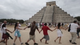Varias personas participan  junto a grupos tradicionalistas de la cultura maya, en un ritual cerca de la pirámide de Kukulkán, en Chichen Itzá,México.