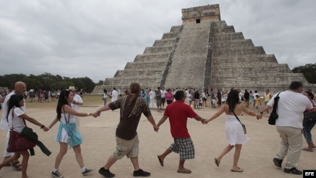 Varias personas participan  junto a grupos tradicionalistas de la cultura maya, en un ritual cerca de la pirámide de Kukulkán, en Chichen Itzá,México.