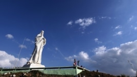 Turistas toman fotos del Cristo de La Habana en La Habana (Cuba). El cardenal cubano Jaime Ortega bendijo este gigantesco monumento, ubicado en una colina frente a la bahía desde la que se avista toda la ciudad, tras concluir las obras de restauración a l