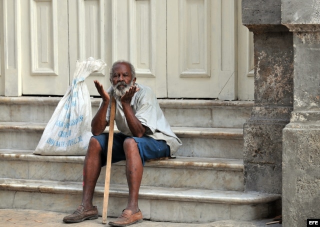 Un anciano permanece sentado en las escaleras del Gran Teatro de La Habana. EFE