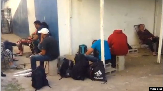 Cubanos detenidos en Costa Rica, de un grupo de 29, esperan en el patio de una unidad policial.
