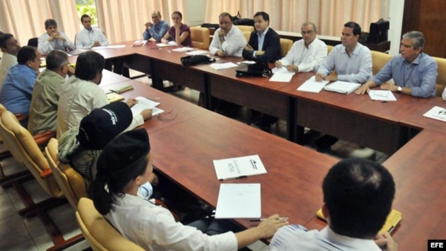 Los negociadores del gobierno de Colombia y de las FARC (de espaldas en la foto) dialogan en La Habana.