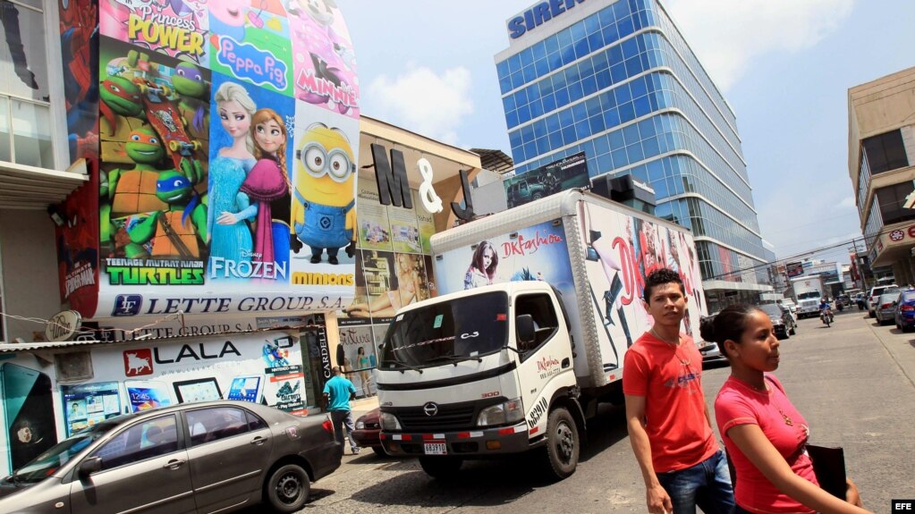 Dos personas cruzan por una calle de la Zona Libre de Colón, adonde concurren tanto agentes comerciales del gobierno como compradores de insumos para el sector privado cubano.