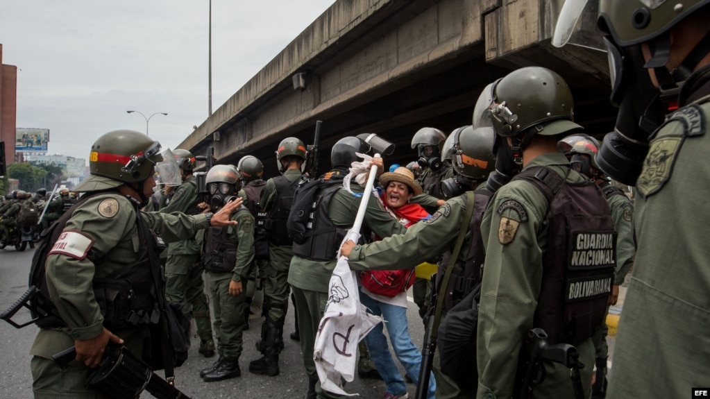 Militares retiran a una mujer que bloqueaba el paso de una tanqueta de la Guardia Nacional durante una manifestaciÃ³n. Foto Archivo