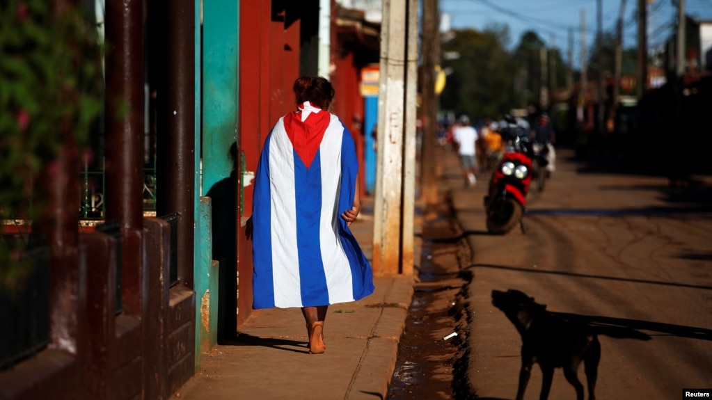 Una persona camina vistiendo una bandera cubana el Alquizar.
