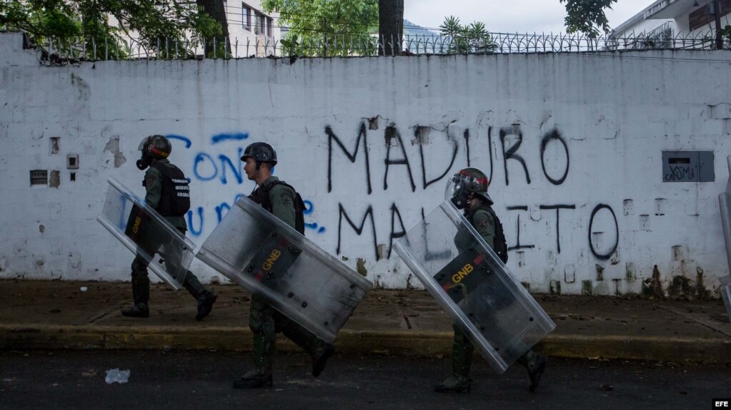 Miembros de la policía se enfrentan con un grupo de manifestantes durante una protesta de opositores al Gobierno venezolano.