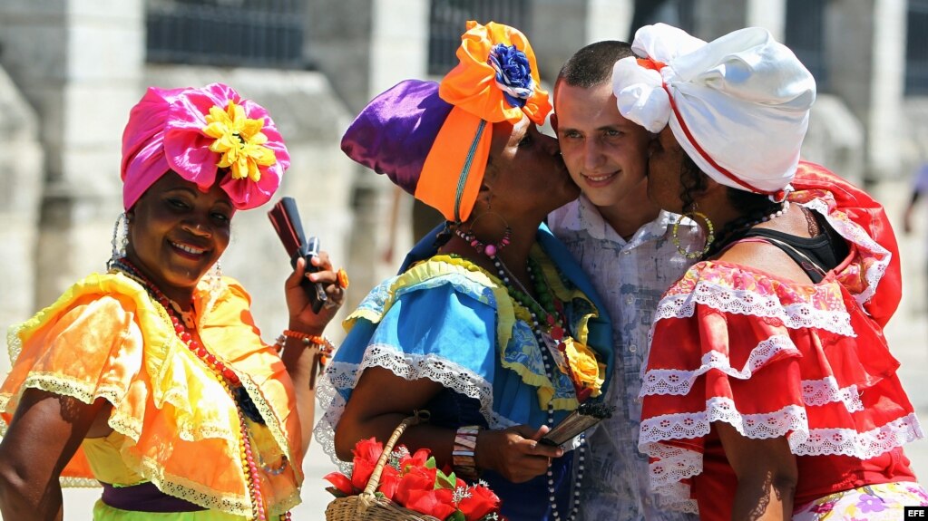 Un turista ruso se toma fotos con mujeres cubanas en la Plaza de Armas de La Habana. (Archivo)