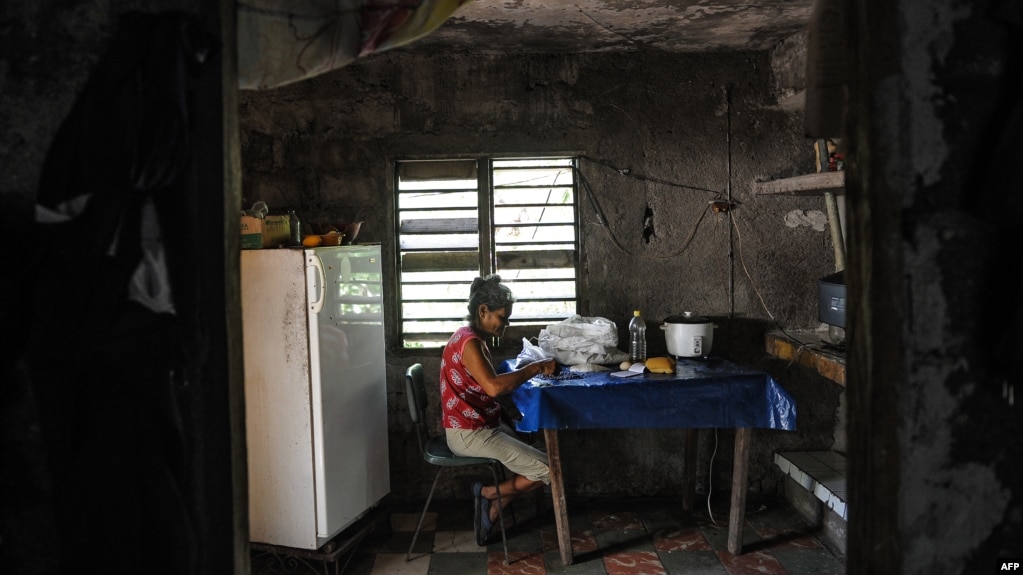 Una señora escoge arroz en su casa en El Caney, Santiago de Cuba el 21 de junio de 2017.