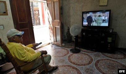 Un hombre ve desde su casa la transmisión en vivo la sesión de la Asamblea Nacional.