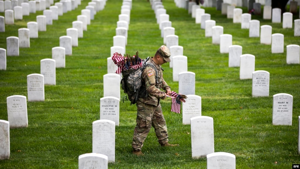 Soldados depositan banderas americanas en cada lápida durante una ceremonia por el Día de los caídos, en el Cementerio Nacional de Arlington, en Virginia.