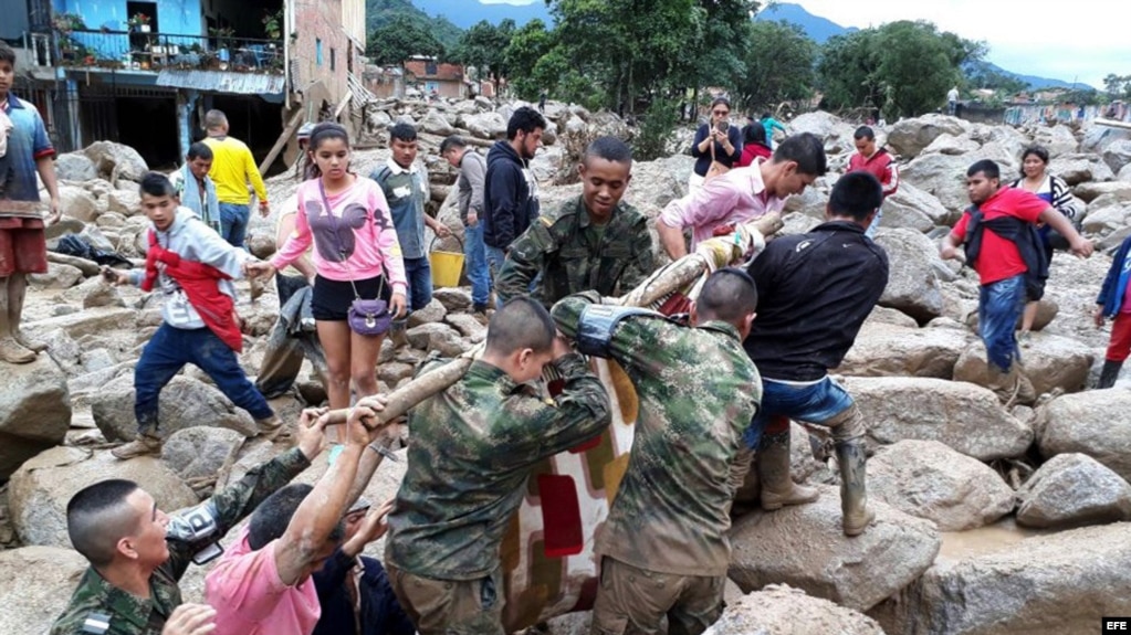 Fotografía cedida por el Ejército de Colombia de sus integrantes ayudando a pobladores por los estragos ocasionados por una avalancha.