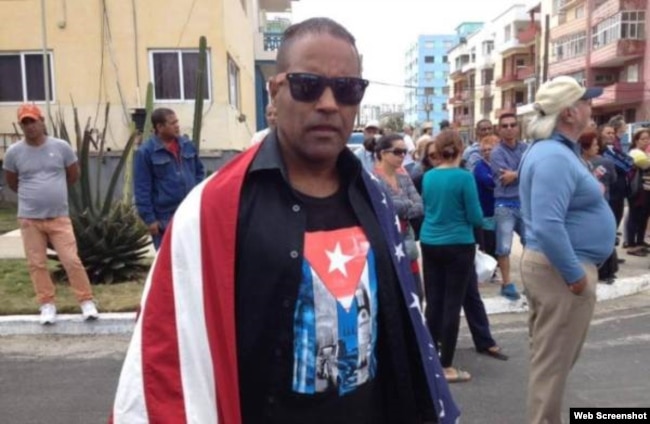 Daniel Llorente se manifiesta envuelto en una bandera estadounidense a la llegada del crucero Adonia a La Habana, en mayo de 2016.