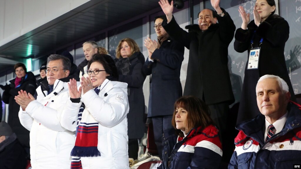 Mientras las dos Coreas desfilan unidas en los JJ.OO. de invierno, el presidente de Corea del Sur (de blanco) y la hermana de Kim Jong Un (der. atrás) aplauden, mientras el vicepresidente de EE.UU., Mike Pence (der., 1ra fila), permanece sentado.
