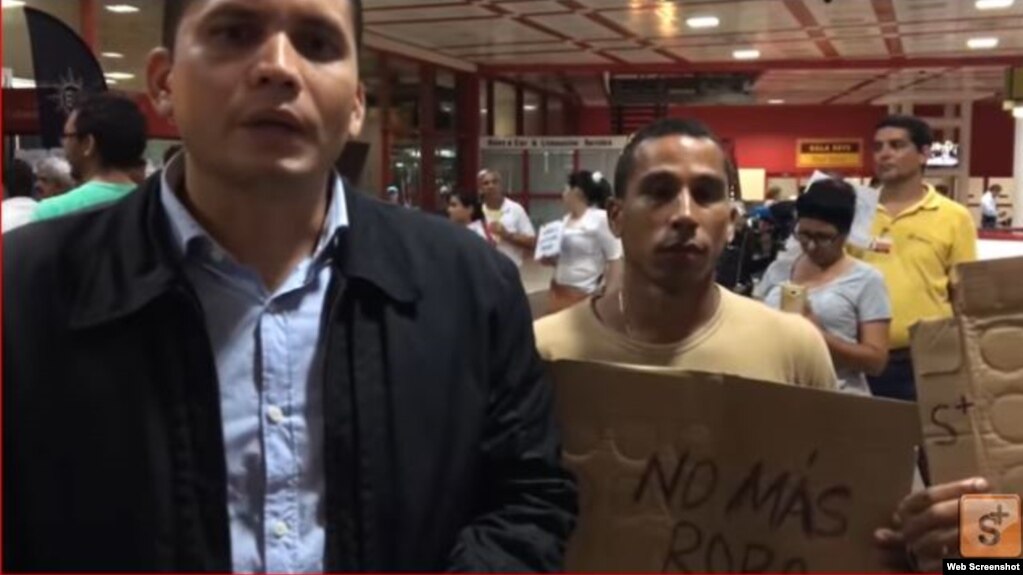 Eliécer Ávila (izquierda) protesta junto a otros miembros de Somos+ en el Aeropuerto Internacional José Martí, de La Habana.