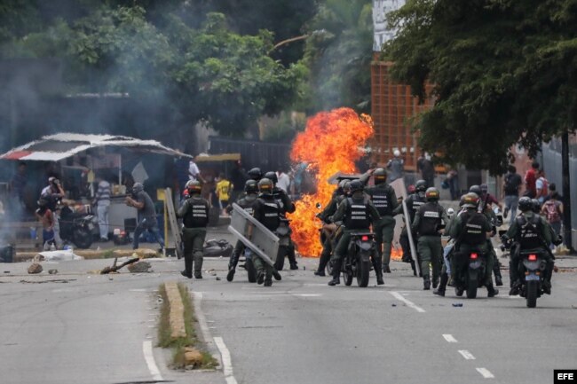 Miembros de la Guardia Nacional Bolivariana (GNB) se enfrentan a un grupo de manifestantes opositores en las inmediaciones de la planta televisiva estatal VTV durante el paro general de 24 horas.