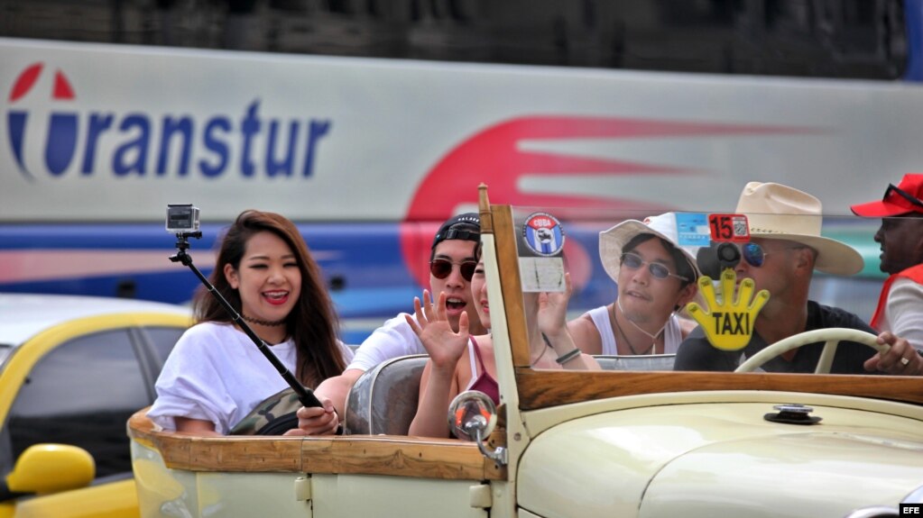 Turistas se toman una selfie durante un paseo en un auto clásico en La Habana.