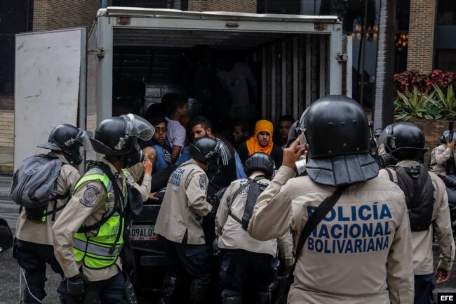 Agentes de la Policía Nacional Bolivariana detienen a manifestantes durante una marcha hacia la sede del Poder Electoral.